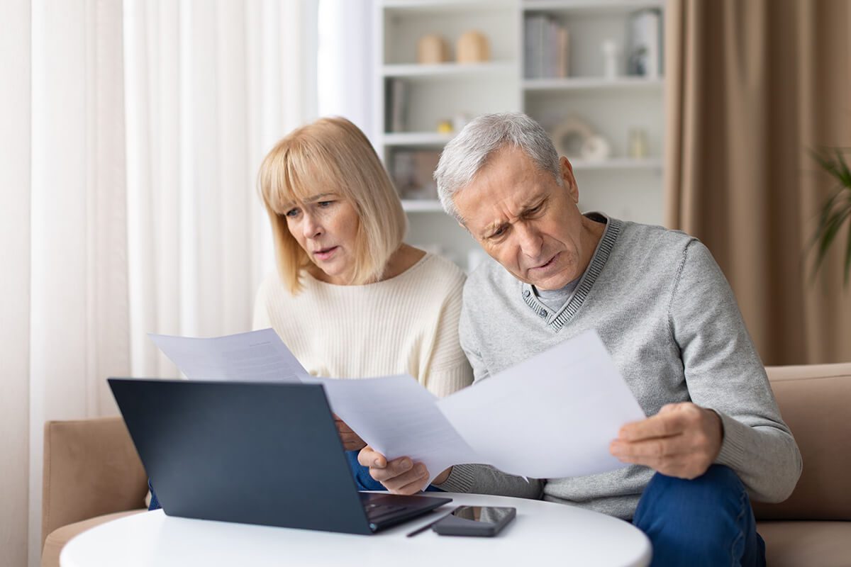 senior couple reading financial papers at home