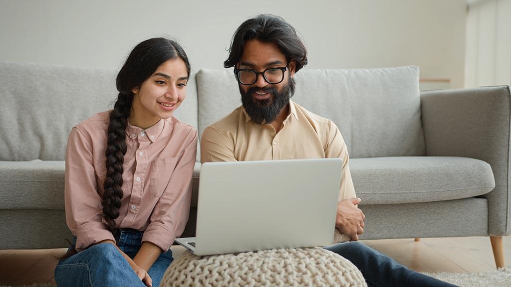 Couple homeowners watching laptop