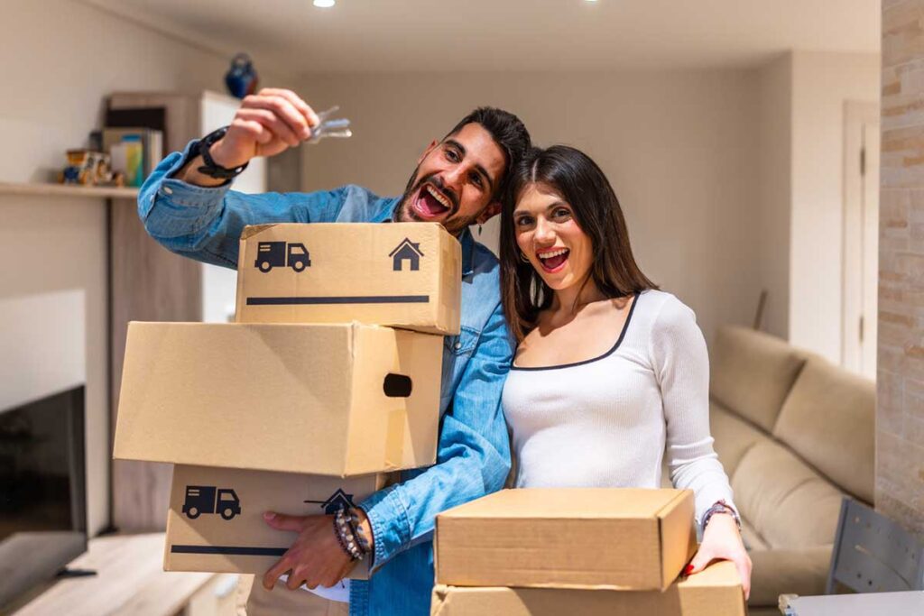 Happy couple showing keys in new home