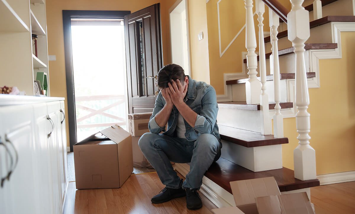 Man sits on the stairs with his head