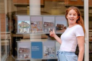 Woman shows interest in property listings in a real estate shop