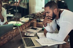 man with documents on laptop for financial planning